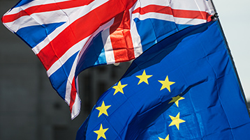 Die britische und die EU-Flagge wehen übereinander.