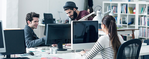 Junge Leute arbeiten in einem großen Büro an Computern. Junge Leute arbeiten in einem großen Büro an Computern.