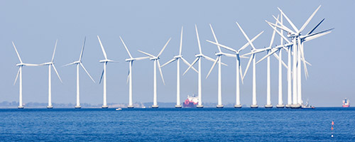 Offshore-Windpark: Eine Reihe Windräder steht im Meer. Offshore-Windpark: Eine Reihe Windräder steht im Meer.