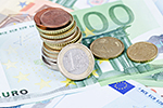 Euromünzen liegen in einem Stapel auf einem einhundert-Euroschein