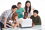 Multikulturelle Studentengruppe schauen gemeinsam auf einen Laptop Multikulturelle Studentengruppe schauen gemeinsam auf einen Laptop